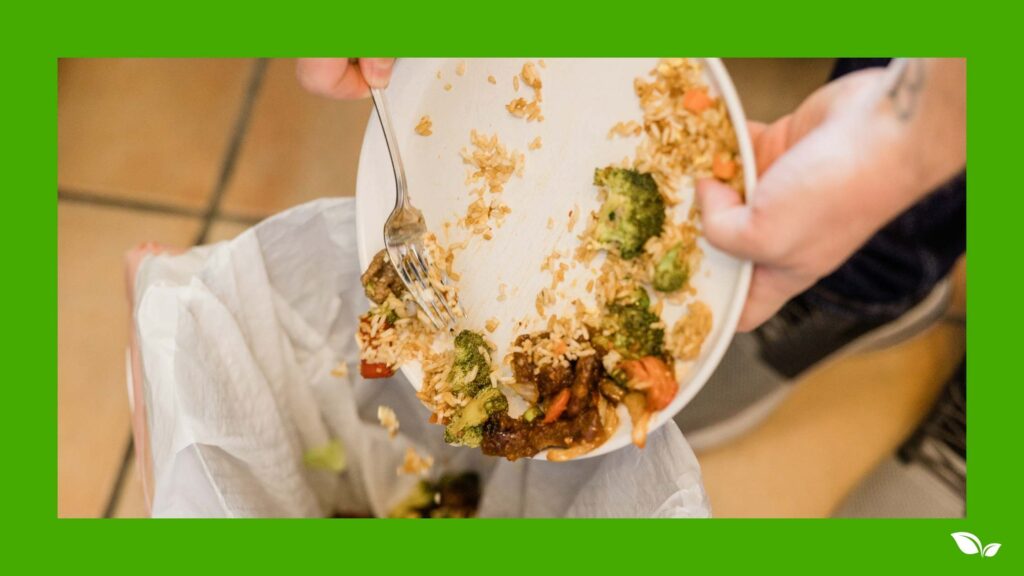 scraping plate into food waste bin